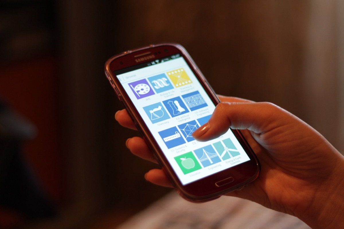 A hand holding a smartphone with an app open on the screen