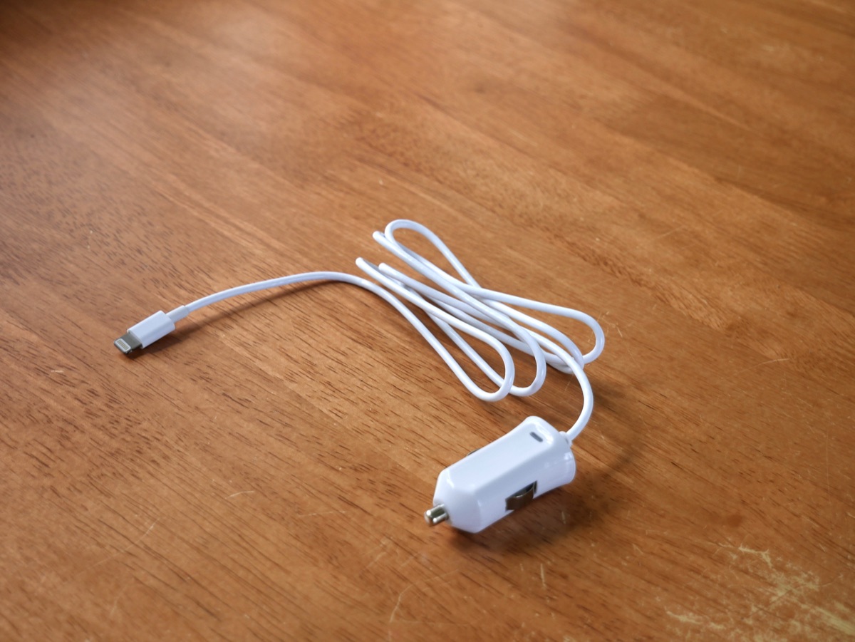 Figure 2.1: A white smartphone car charger and cable on a wooden table