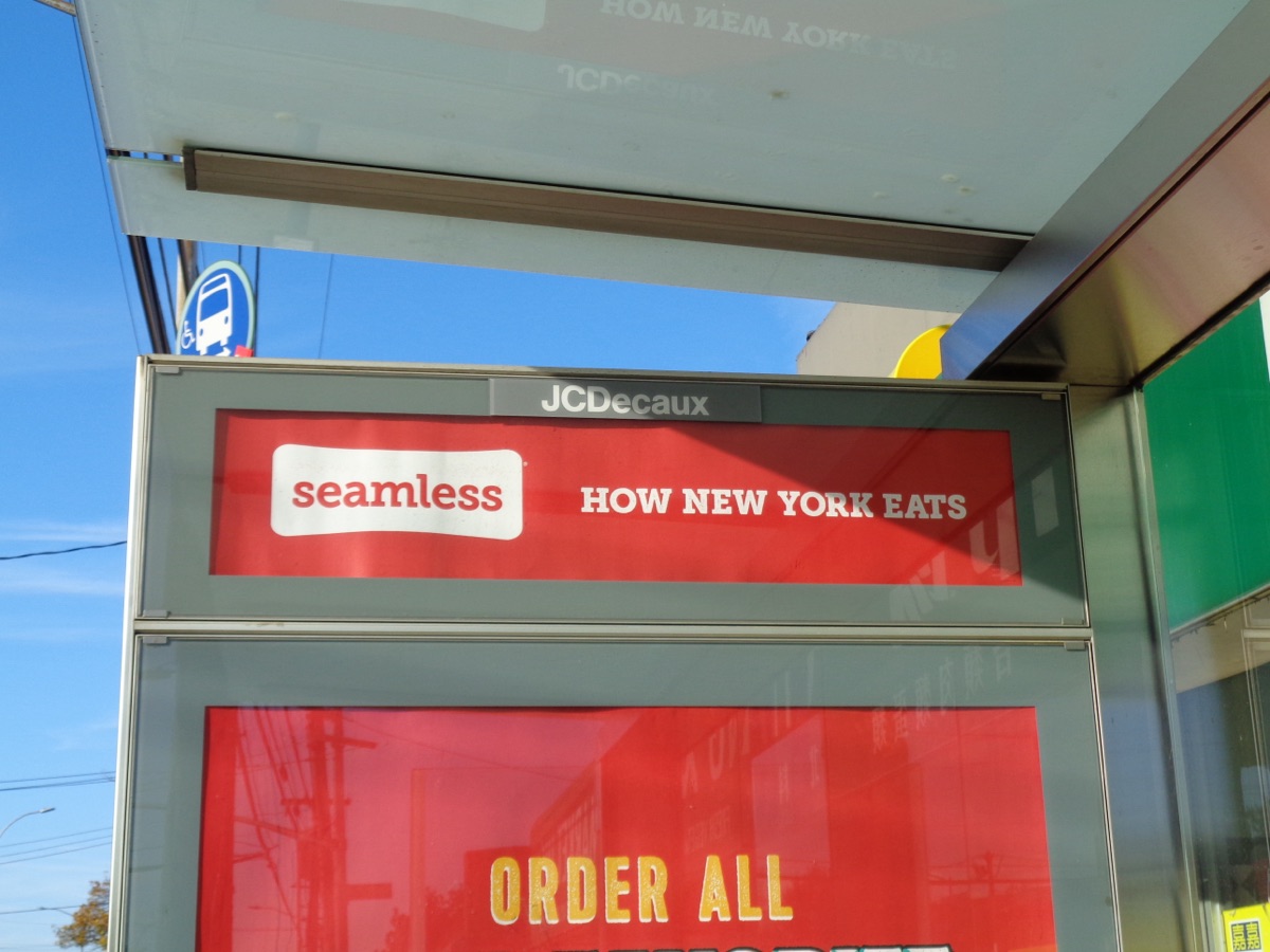 Figure 1.1: A Seamless advertisement reading How New York Eats on a bus shelter in Queens, New York